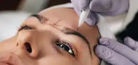 Close-up of Beautician Doing Permanent Brow Tattoo