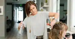 woman wearing gray top holding gray spray bottle