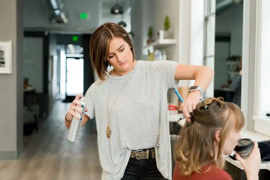 woman wearing gray top holding gray spray bottle